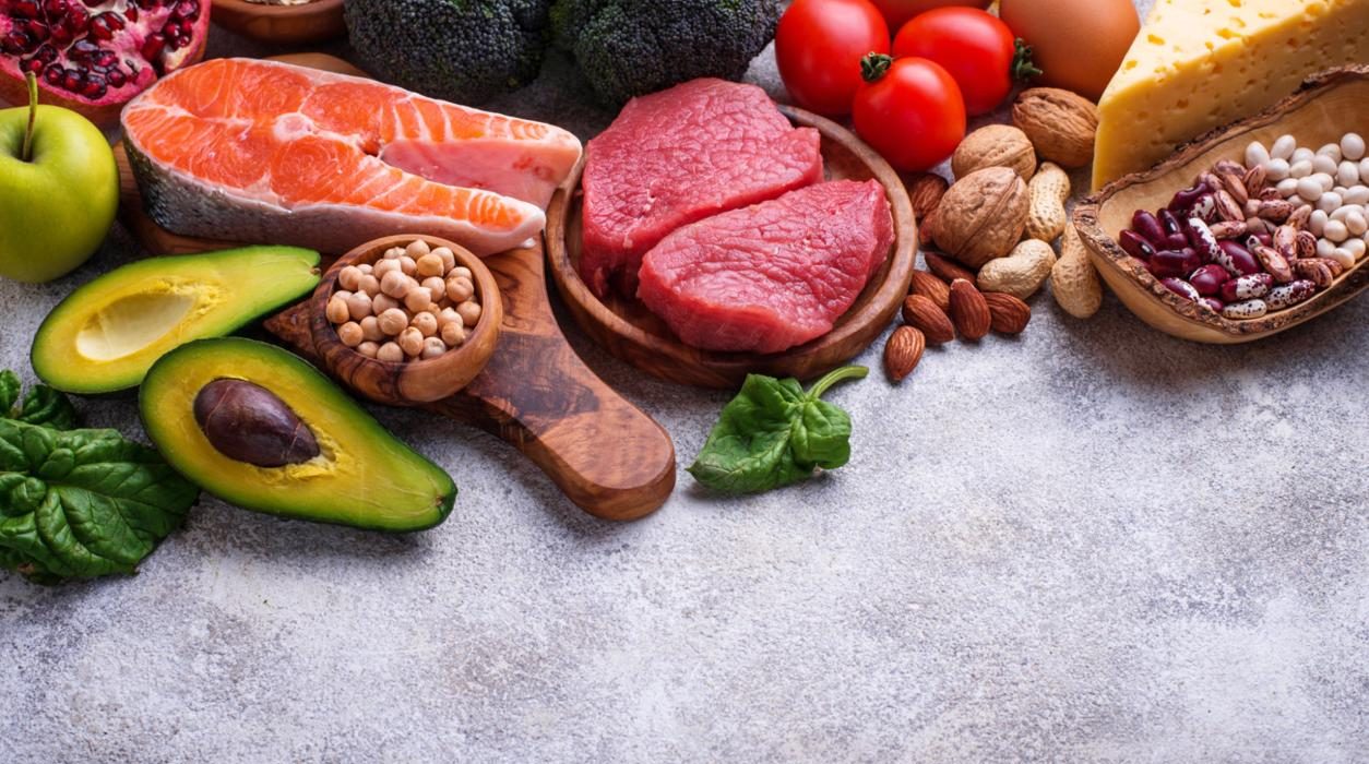 Healthy assortment of nutrient-rich foods including salmon berries leafy greens nuts and vegetables