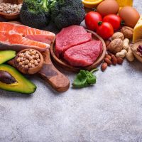 Healthy assortment of nutrient-rich foods including salmon berries leafy greens nuts and vegetables