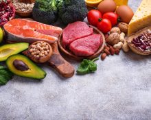 Healthy assortment of nutrient-rich foods including salmon berries leafy greens nuts and vegetables
