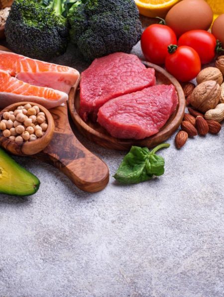 Healthy assortment of nutrient-rich foods including salmon berries leafy greens nuts and vegetables