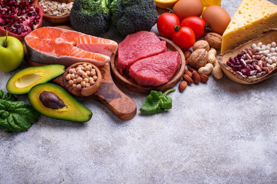 Healthy assortment of nutrient-rich foods including salmon berries leafy greens nuts and vegetables